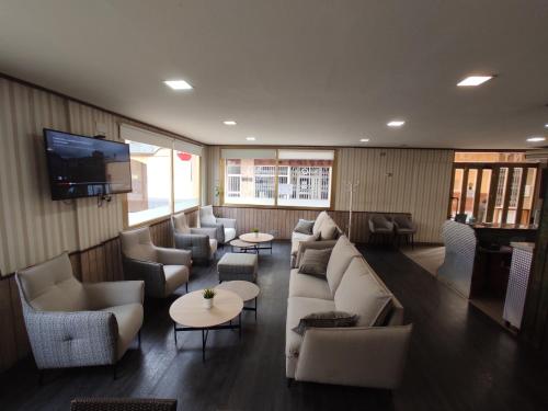 salon z kanapami i stołami oraz telewizorem w obiekcie Hotel Querol w mieście Valderrobres