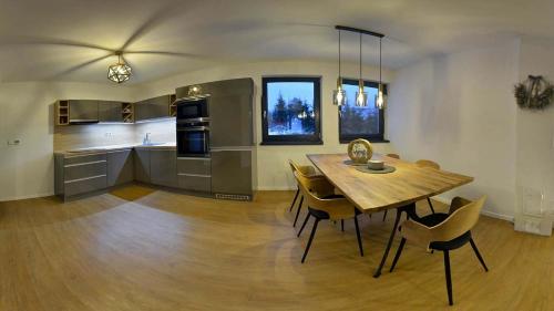 kuchnia i jadalnia z drewnianym stołem i krzesłami w obiekcie Apartmány Fun & Relax Dolní Morava w mieście Dolní Morava