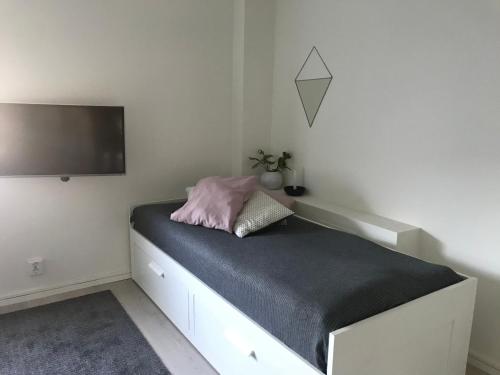 a bedroom with a bed with a tv on the wall at Mysig studiolägenhet i Västra Göteborg in Västra Frölunda