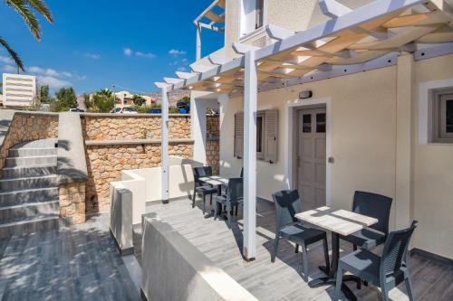 a patio with tables and chairs under a pergola at Villa Eleftheria in Perivolos
