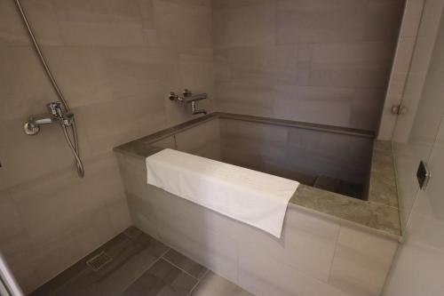a bathroom with a bath tub with a towel at Hotel Shumei Chiayi in Zhongpu