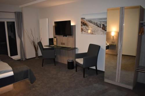 a hotel room with a bed and a desk with chairs at Hotel Neue Stuben in Wolfsburg