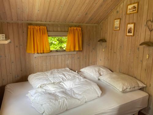 En eller flere senge i et værelse på Lille 2-personers hytte på Rinkenæshus Camping - Hytte A
