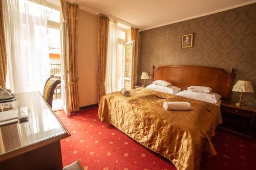 um quarto de hotel com uma cama com toalhas em Mozart Hotel em Szeged