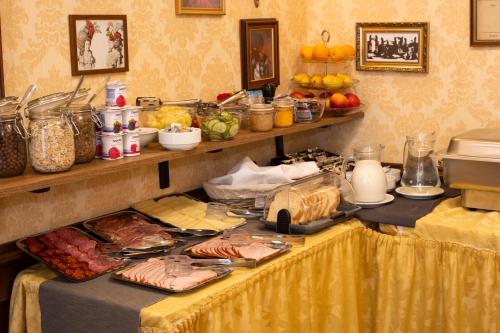 a table with meat and other food on it at Mozart Hotel in Szeged