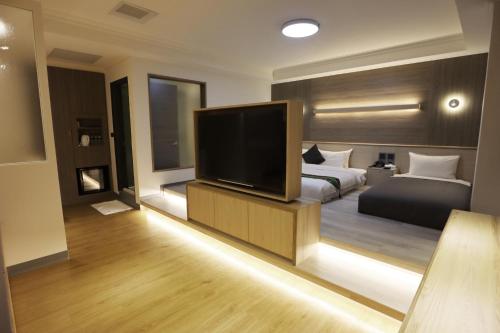 a bedroom with a bed and a flat screen tv at Hotel Shumei Chiayi in Zhongpu