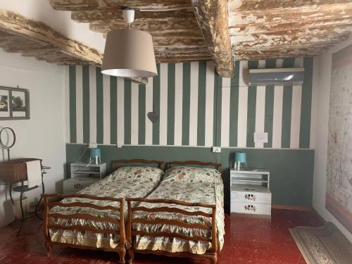 um quarto com uma cama e uma parede listrada em Fattoria Amelia em Santa Caterina