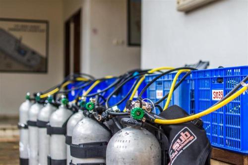 Eine Reihe von Wasserflaschen stand neben einer blauen Kiste. in der Unterkunft Siddhartha Oceanfront Resort & Spa Bali in Tulamben