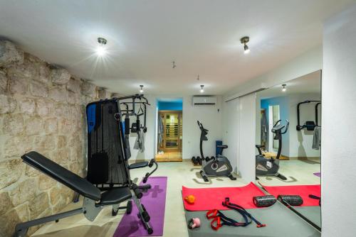 a fitness room with treadmills and exercise bikes at Villa Dovecote with Private Sauna, Jacuzzi & Gym in Ston