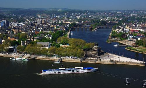 a cruise ship in a river near a city at Mercure Hotel Koblenz in Koblenz