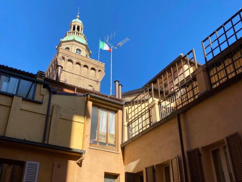 a clock tower with a flag on top of a building at UR-NEST De' Fusari in Bologna