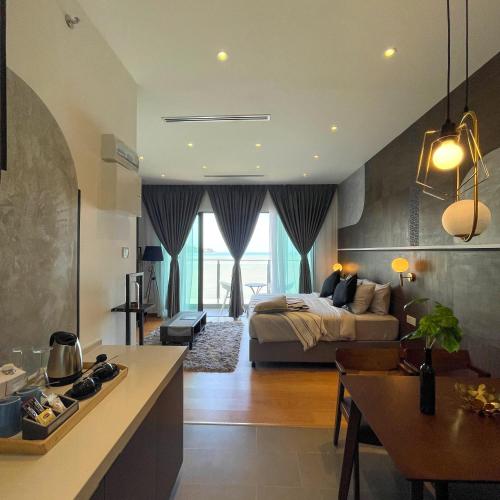 a bedroom with a bed and a kitchen with a table at Swiss-Belhotel Kuantan in Kuantan
