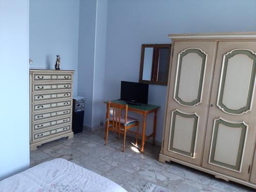 a bedroom with a dresser and a desk next to a bed at Villa Paulette in Bassignana