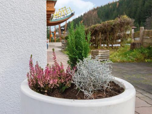 a white planter with flowers and plants in it at Apartment in Wald near Zillertal Ski Slopes in Wald im Pinzgau