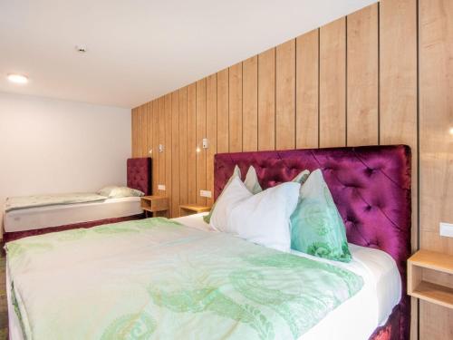 a bedroom with a large bed with a purple headboard at Apartment in Wald near Zillertal Ski Slopes in Wald im Pinzgau