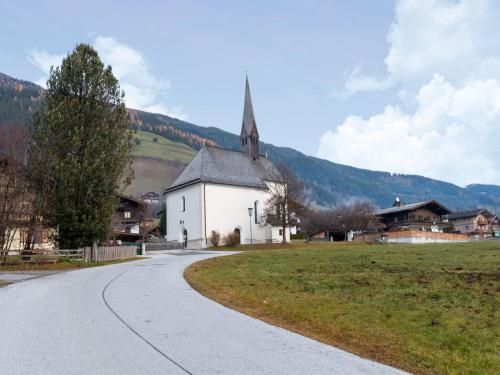 a small white church with a steeple on a road at Apartment in Wald near Zillertal Ski Slopes in Wald im Pinzgau