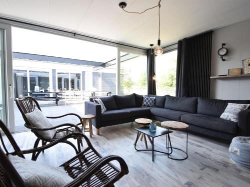 een woonkamer met een blauwe bank en stoelen bij Classy Holiday Home in Sint Annaland with Garden Barbecue in Sint Annaland