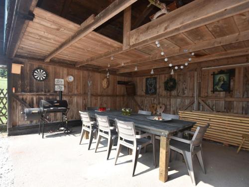 un comedor de madera con una mesa larga y sillas en Comfortable holiday home with private pool en Levínská Olešnice