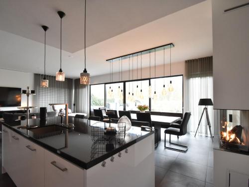 een open keuken en een woonkamer met een open haard bij Modern Villa in Harderwijk with Sauna and Jacuzzi in Harderwijk