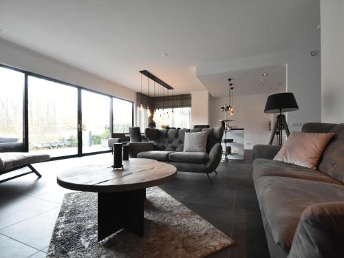 een woonkamer met banken en een tafel bij Modern Villa in Harderwijk with Sauna and Jacuzzi in Harderwijk
