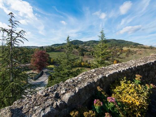 a stone retaining wall with flowers and trees at Romantic Medieval Escape in Petrella Guidi