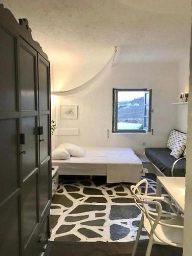 a small room with a bed and a window at Opis studio in Ornos