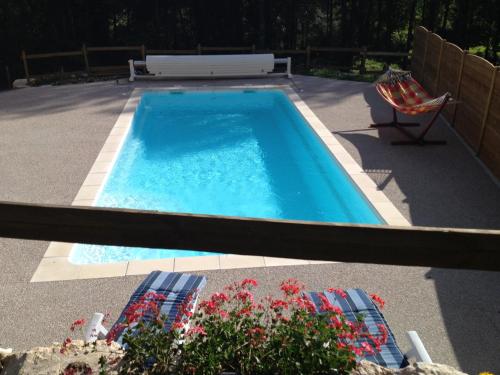a swimming pool with two chairs and a table at Le Mas de Servant Roulottes et chambres d'hôtes in Auberives-en-Royans