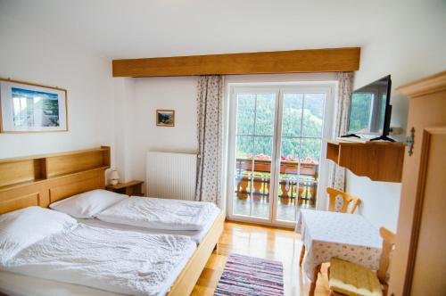 Schlafzimmer mit einem Bett und einem Fenster in der Unterkunft Gästehaus Berger - Priglhof in Treffen