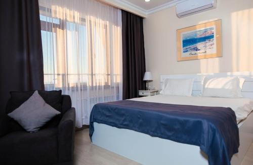a bedroom with a bed and a couch and a window at Chagala Bautino Hotel in Bautino