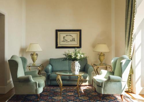 a living room with two chairs and a couch and a table at Grand Hotel Timeo, A Belmond Hotel, Taormina in Taormina