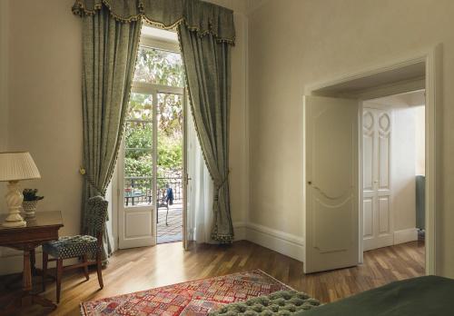 a bedroom with a door leading to a patio at Grand Hotel Timeo, A Belmond Hotel, Taormina in Taormina