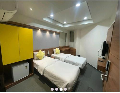 a hotel room with two beds and a tv at Hotel Avaante Ahmedabad Formerly known as The Orchid Hotel in Ahmedabad