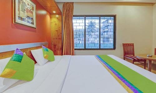 a bedroom with a large white bed with a window at Treebo Suraksha Inn in Bengaluru
