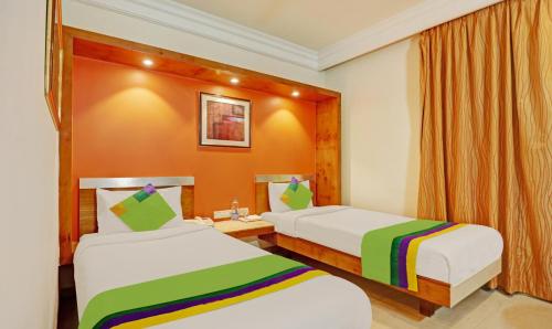 a hotel room with two beds with rainbow sheets at Treebo Suraksha Inn in Bengaluru