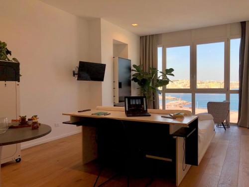 a living room with a desk with a laptop on it at La Vacanza Ortigia in Siracusa