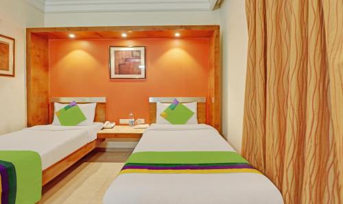 a hotel room with two beds and a desk at Treebo Suraksha Inn in Bengaluru