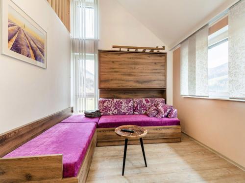 Apartment in St Georgen Salzburg near ski area في فورستاو: غرفة نوم بسرير ارجواني وطاولة