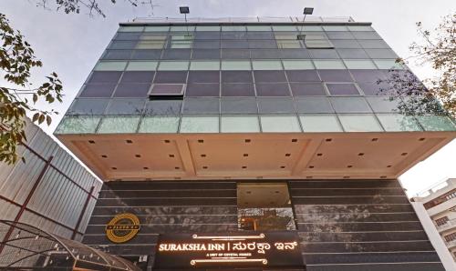 a tall building with a sign in front of it at Treebo Trend Suraksha Inn in Bangalore