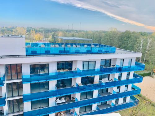 an apartment building with blue balconies on it at Aquarius Santorini in Boszkowo