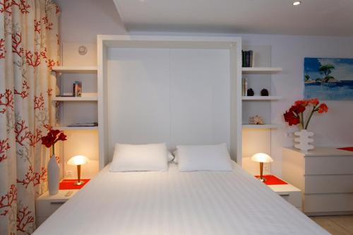 a bedroom with a large white bed with two pillows at Studio Kalliste - Vision Luxe in Bonifacio