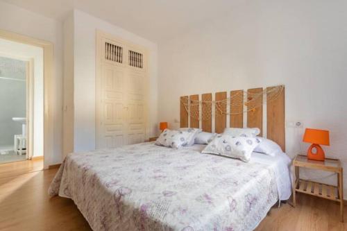 1 dormitorio con 1 cama grande con sábanas y almohadas blancas en Cala Blanca Javea/Residence, beach, pool, tenis A/C, en Jávea
