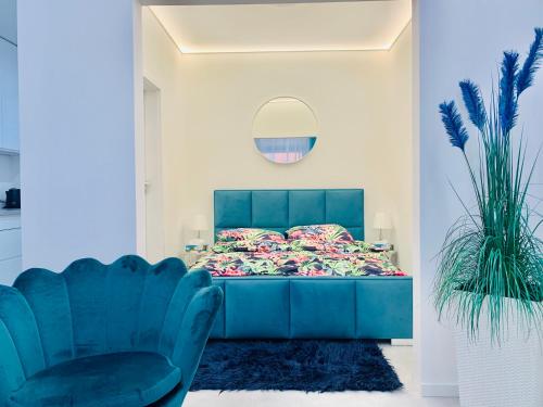 a bedroom with a blue bed and a blue chair at Aquarius Santorini in Boszkowo