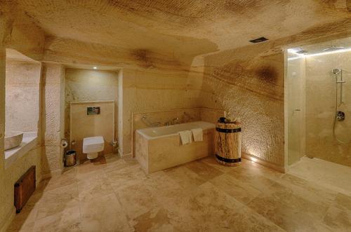 a large bathroom with a tub and a shower at Taru Cave Suites in Urgup