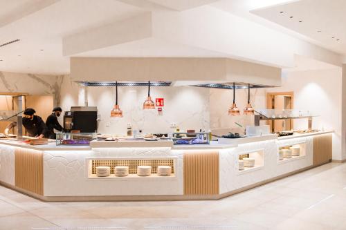 a kitchen with two people preparing food in a restaurant at Gran Sagitario in Ciutadella