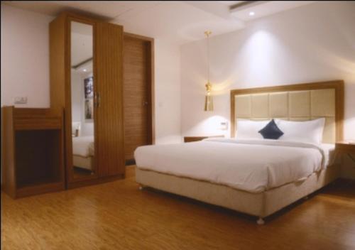 een slaapkamer met een groot bed en een spiegel bij HOTEL AMORA - Rajnandgaon in Rāj Nāndgaon
