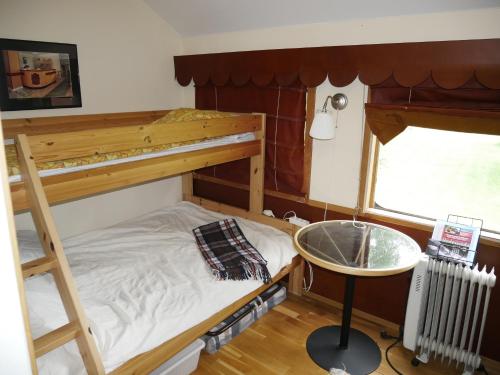 a bedroom with a bunk bed and a desk in it at SovPå Tåg i Tärnsjö in Tärnsjö