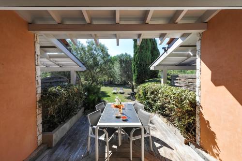 un patio avec une table et des chaises sous une pergola dans l'établissement Studio Kalliste - Vision Luxe, à Bonifacio