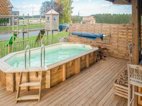 a hot tub on a deck with a wooden fence at Luxurious house with sauna in a farm in Bastogne in Bastogne