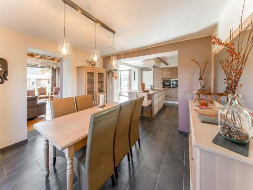 a kitchen and dining room with a wooden table and chairs at Luxurious house with sauna in a farm in Bastogne in Bastogne