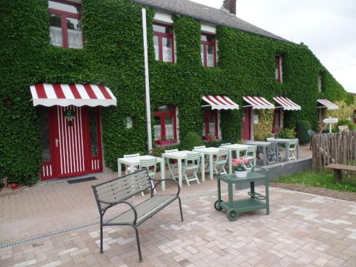 een gebouw met tafels en stoelen ervoor bij Charming farmhouse in Aublain with a spacious terrace in Aublain